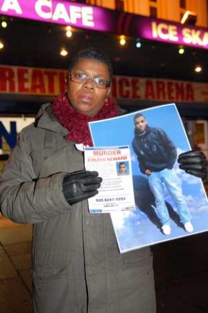 Tracey Ford holds a picture of her son outside the ice rink where he was murdered
