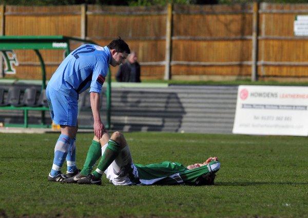 Down and out: Kingstonian's Bobby Traynor consoles Leatherhead's Harry Ottaway after relegation