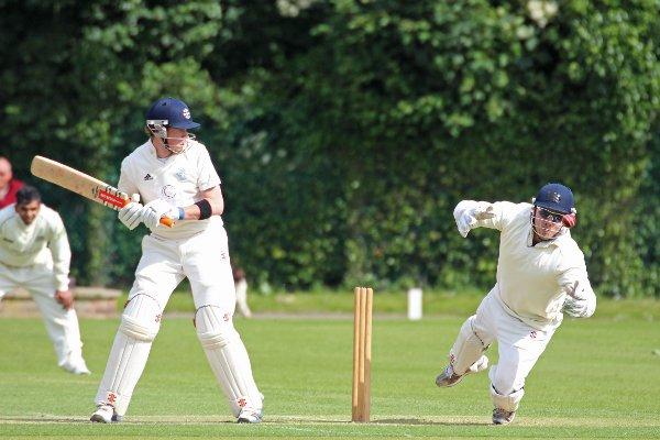 Nervous: Teddington batsman Chris Paget looks on nervously as Eastcote keeper Adam Rossington juggles an attempted catch during Saturday’s Middlesex County League Premier Division clash in windy conditions at Bushy Park.
