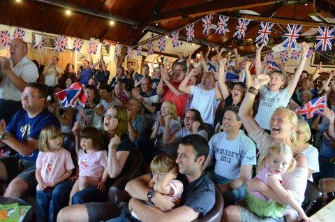 Land of hope and glory: Molesey Boat Club members cheer on club captain Andrew Triggs Hodge and Tom James at the club's Barge Walk base in East Molesey