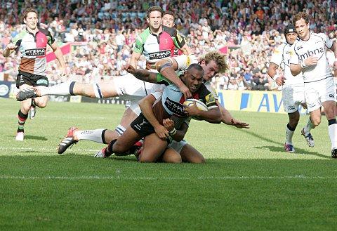 Muscle: Quins centre Jordan Turner-Hall dives over for his first half try despite close attention from the Sale defence