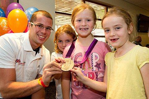 Surgery required: Hampton's James Foad shows off his medal to children at his David Lloyd Hampton