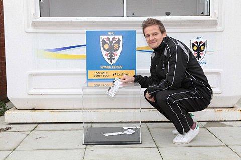 Ticket amnesty: Dons boss Neal Ardley drops his ticket in the box, but of course he does not need one anyway
