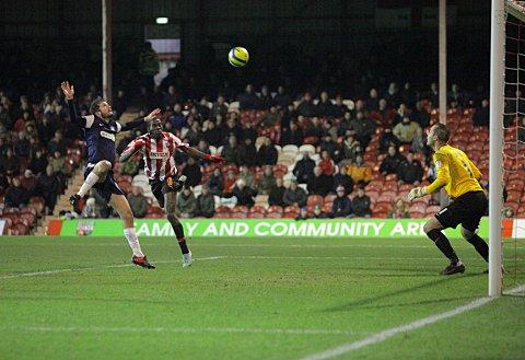 On target: Clayton Donaldson gets up to head towards goal only to find former Bees keeper Paul Smith in fine form on Tuesday