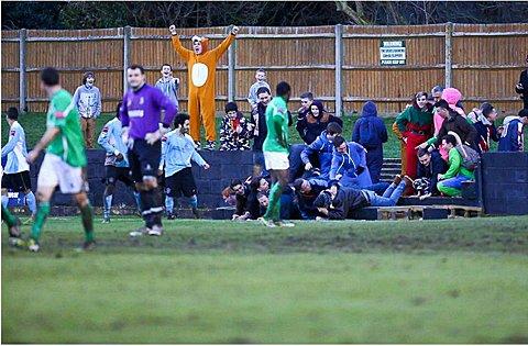 Front of the terracing collapses as Dulwich Hamlet supporters celebrate. Photo: Neil Hood