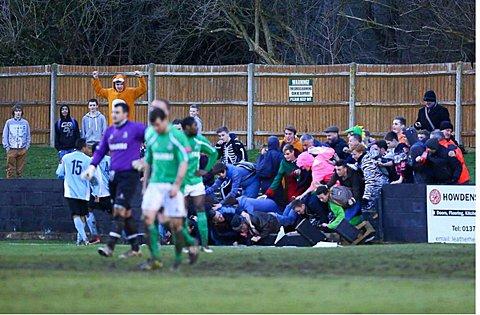 Scary moment: Celebrating fans are left sprawling after the wall collapsed when Dulwich Hamlet scored their second goal at Leatherhead – the match was abandoned with 12 minutes remaining Picture: Neil Hood