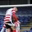 Threesome: Lewis Taylor climbs aboard as Wade Small, right, congratulates Andre McCollin on his strike