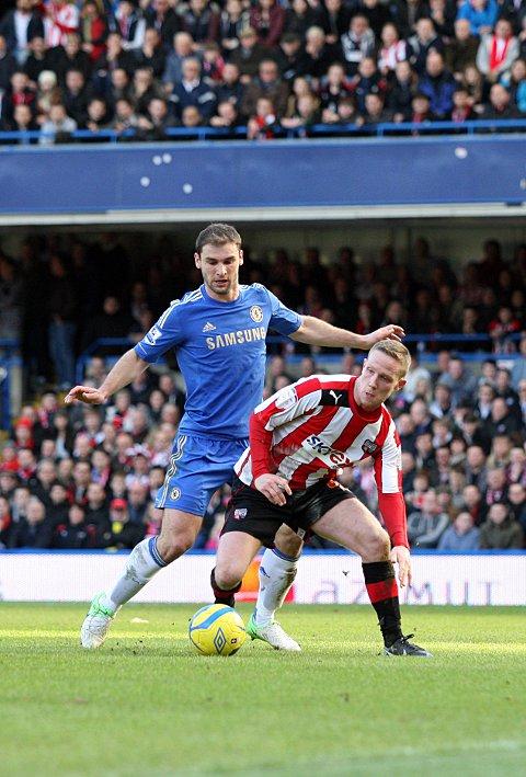 Looking up: Adam Forshaw feels the force of Chelsea defender Branislav Ivanovic on Sunday