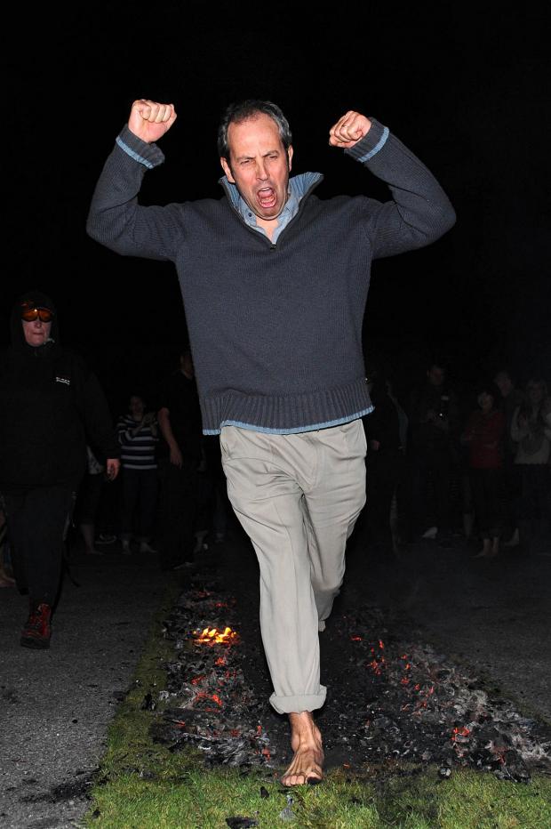 Mr Duggan taking part in a fire walk last year.