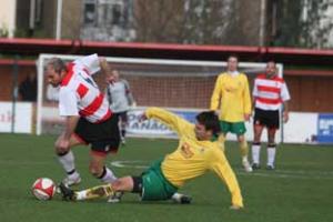 Getting stuck in:  Kingtonian's Tommy Williams puts the boot in against Godalming Town earlier this season.